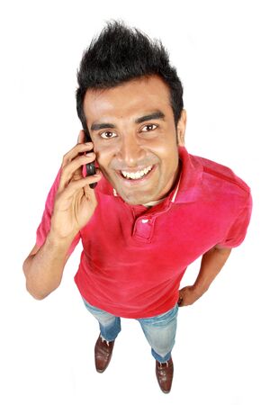 Asian man smiling using a mobile phone as a mode of communicationの写真素材