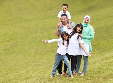 Happy family with three children. Father, mother, daughters and son in the parkの写真素材