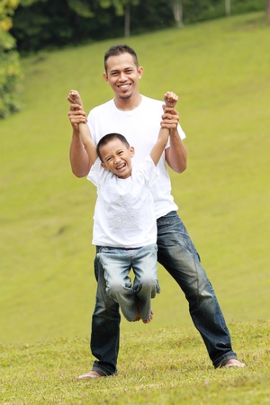 father playing with his son outdoors in the parkの写真素材