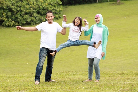 Portrait of happy parents and their daughter having fun outdoorの写真素材