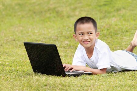 kid with laptop outdoor in the parkの写真素材