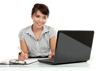 Business woman working on laptop computer isolated over white backgroundの写真素材