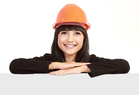 Female engineer with a banner isolated over a white backgroundの写真素材