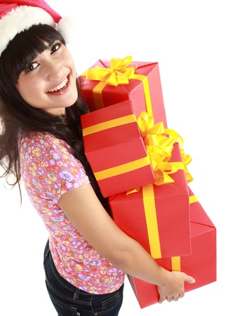 Top view of Christmas woman holding gifts wearing Santa hat. Standing in full body isolated on white background. Smiling woman portrait of a beautiful Asian  model.の写真素材