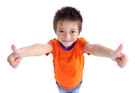 Portrait of a smilling cute little boy gesturing thumbs up sign agaist white backgroundの写真素材