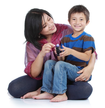 young little son embracing his pretty young mother in isolated over whiteの写真素材