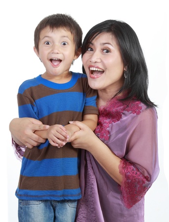 young little son embracing his pretty young mother in isolated over whiteの写真素材