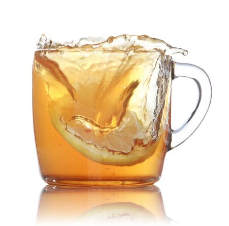 lemon slice falling in to glass with ice tea isolated over white backgroundの写真素材