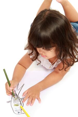 little pretty girl drawing and coloring with pencil color on a white backgroundの写真素材