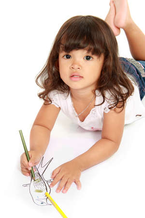 little pretty girl drawing and coloring with pencil color on a white backgroundの写真素材