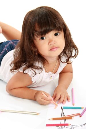 little pretty girl drawing and coloring with pencil color on a white backgroundの写真素材