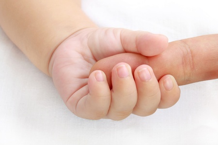 little baby hand holding a mother's fingerの写真素材