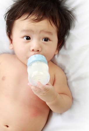 Little baby drinking milk from bottle.の写真素材