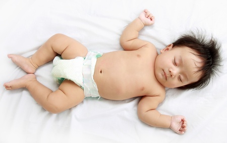 Close up of adorable little baby laying in the bed.の写真素材