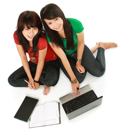 top view of Two girls-students with laptop sitting on white backgroundの写真素材
