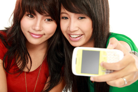 two happy woman take a photo of her self isolated on white background