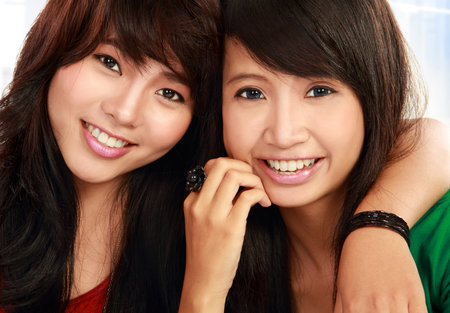 close up portrait of attractive two teenage girls hugging each other