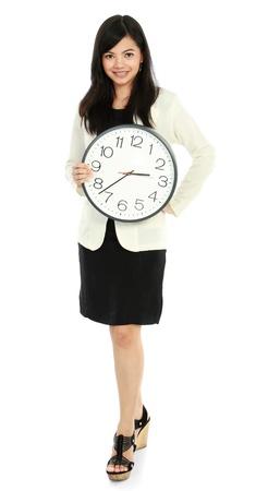 Pretty smiling asian business woman holding a clockの写真素材