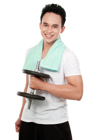 portrait of a handsome young healthy sports man with dumbbell smiling looking at cameraの写真素材