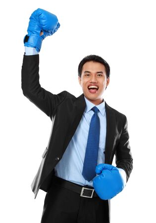portrait of happy businessman with boxing glove raise his handの写真素材