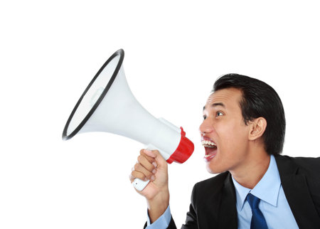 close up portrait of young man shouting using megaphone isolated on white backgroundの写真素材