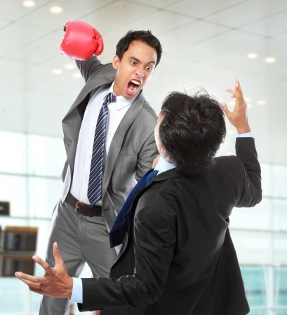 businessman hit his rival in the face at the officeの写真素材