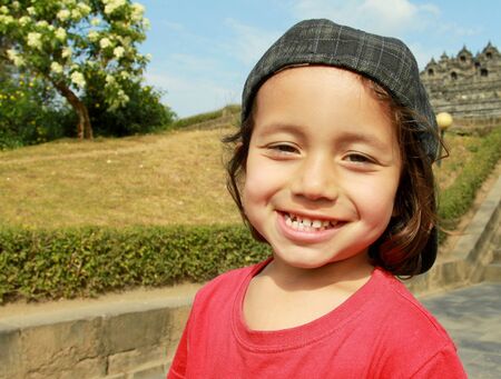 close up portrait of kid in green nature smiling to the cameraの写真素材