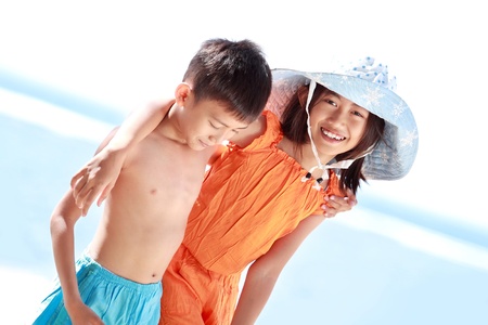 Portrait of happy asian kids having fun in beautiful sunny day in the beachの写真素材