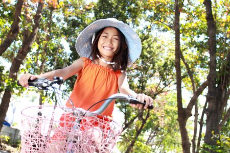 happy attractive litte girl riding bicycle outdoorの写真素材