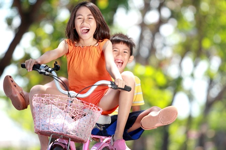 happy smiling kids enjoy riding bicycle together outdoorの写真素材