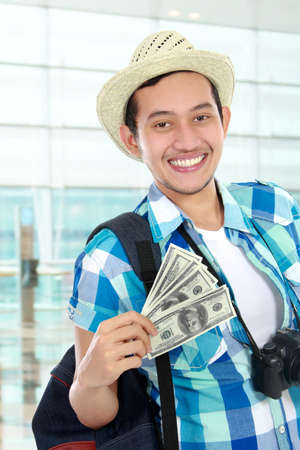 young happy traveler holding some moneyの写真素材