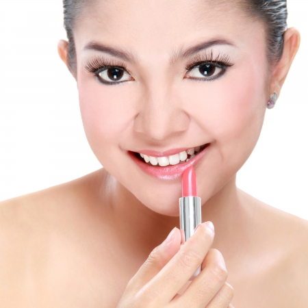 attractive woman portrait on white background applying lipstickの写真素材