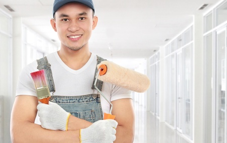 Painter with paintbrush ready to paint the wallの写真素材