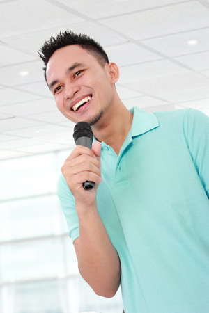 Close up of young man talking with microphoneの写真素材