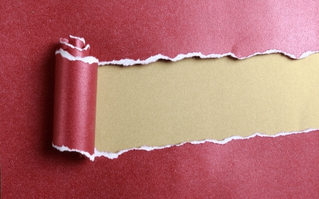 ripped red paper over gold color backgroundの写真素材