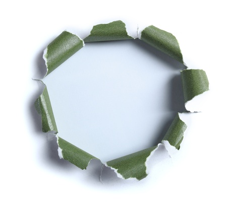 Hole ripped in white paper with green paper on light blue backgroundの写真素材
