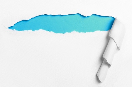 ripped white paper over blue color backgroundの写真素材