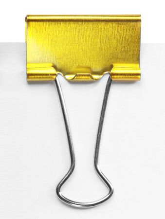 Close up of a yellow binder clip attached to sheet of paperの写真素材
