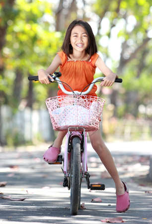 Portrait of asian cute little girl riding bicycle outdoorの写真素材