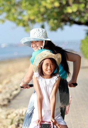 Young little girl having fun with bicycle outdoor and looking at the cameraの写真素材