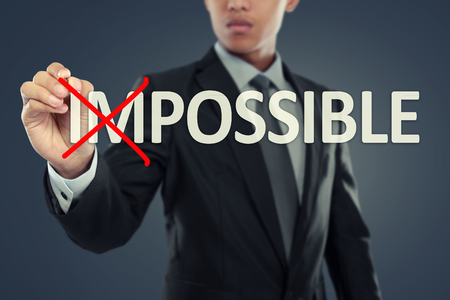 Businessman changing word impossible into possible on virtual backgroundの写真素材