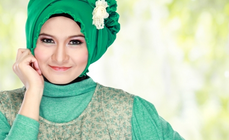 Fashion portrait of young beautiful muslim woman with green costume wearing hijabの写真素材