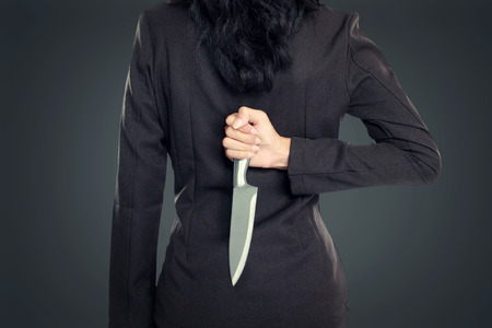 Business woman Holding Knife Behind His Back. conceptual imageの写真素材