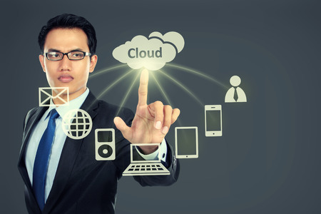 Business man pointing at cloud computing on virtual backgroundの写真素材