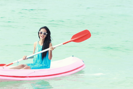 woman having fun kayaking on a sunny day at the beachの写真素材