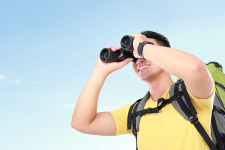 Hiker man tourist looking around with binoculars. Hikingの写真素材
