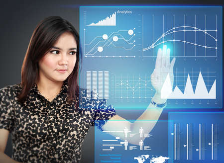 Portrait of Businesswoman pointing to a graph on transparent touchscreenの写真素材