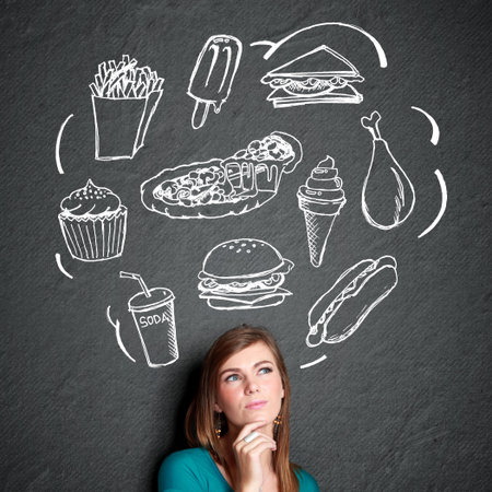 portrait of confuse young woman looking up thinking what to eat. fast food conceptの写真素材