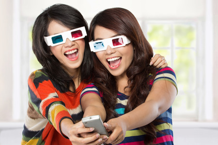 Teenager watching a 3D movie with retro 3D glassesの写真素材