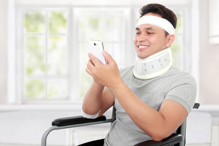 portrait of injured young man play on his smartphoneの写真素材